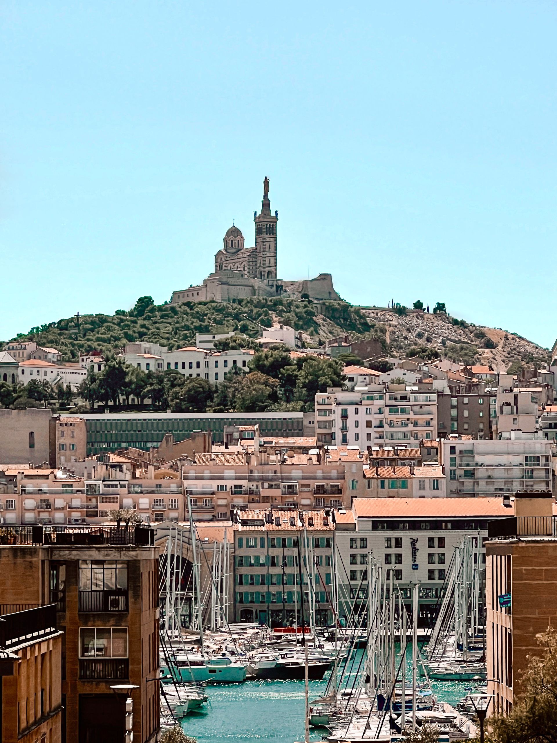 Beautiful view of Notre-Dame de la Garde overlooking the city and marina in Marseille, France.